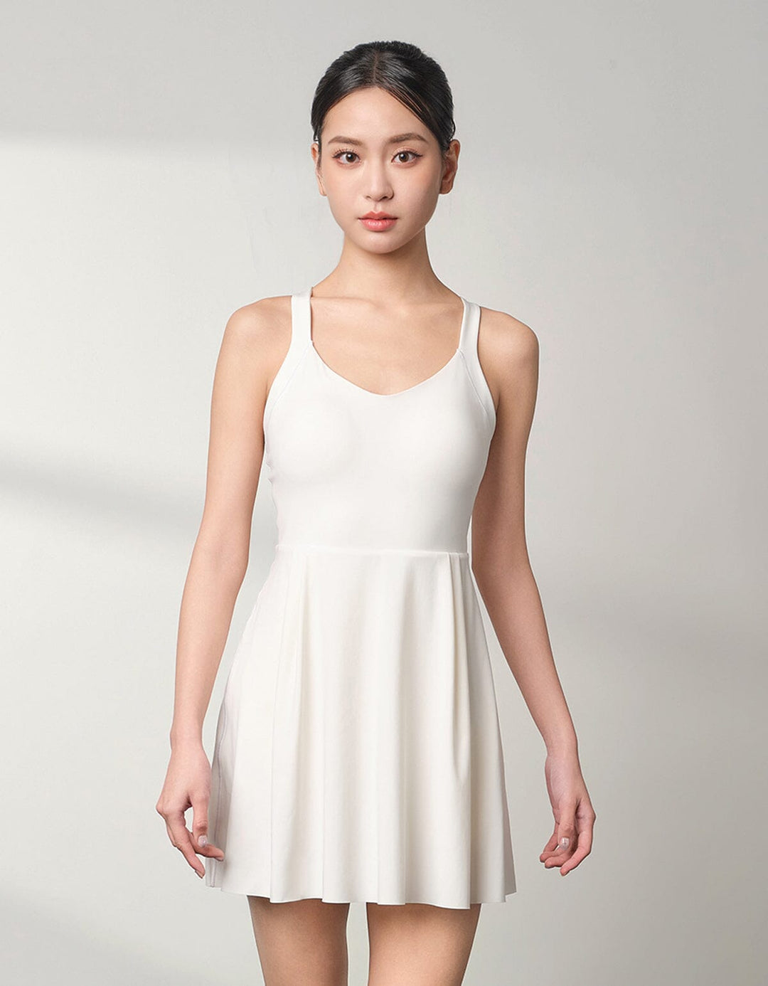 A beautiful girl is wearing a white FLOAT Tennis Dress from Her own words SPORTS 